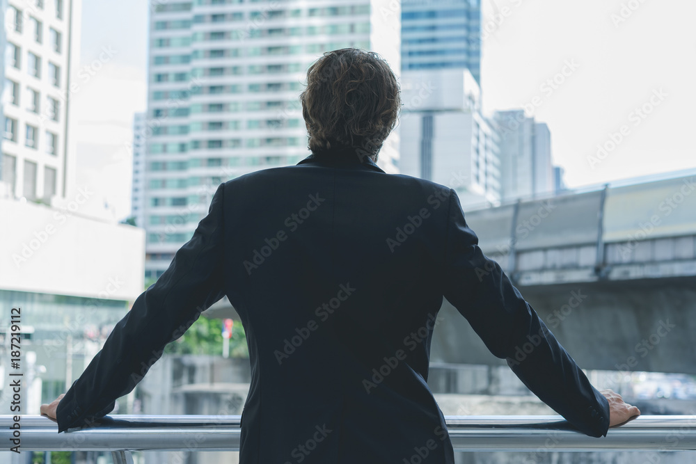 Smart businessman in full suit standing outdoors in cityscape background
