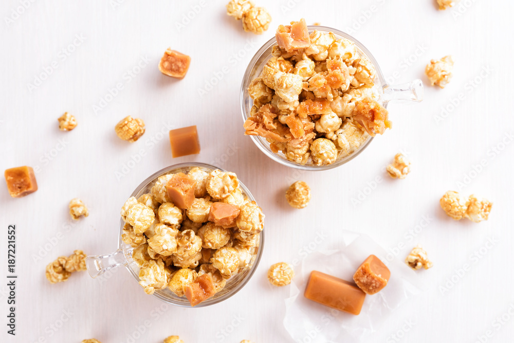 Two glasses of caramel popcorn. Homemade golden sweet corn on white table Two glasses of caramel popcorn. Homemade golden sweet corn on white table
