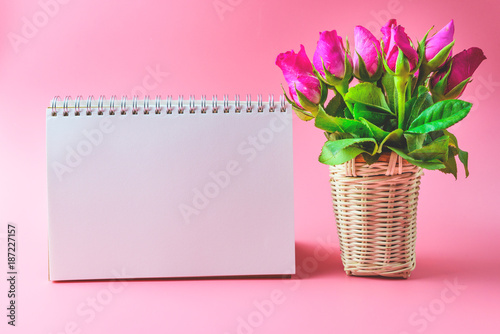 Fototapeta Naklejka Na Ścianę i Meble -  Basket of Pink roses decorative with blank notepad on top view flat lay for your text,for valentine and wedding sweet love concept vintage tone on pink background