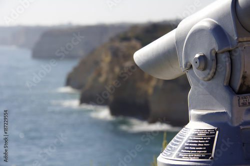 Sightseeing coin operated telescope on the cliffs used for looking out into the sea in Carvoeiro, Algarve, Portugal. Wording on the telescope is instructions on how to use the machine.