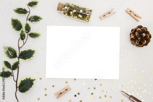 Magic Christmas. Blank card invitation banner mockup, festive stationery and decorations, golden stars, green branch, pine cone, clothspins
