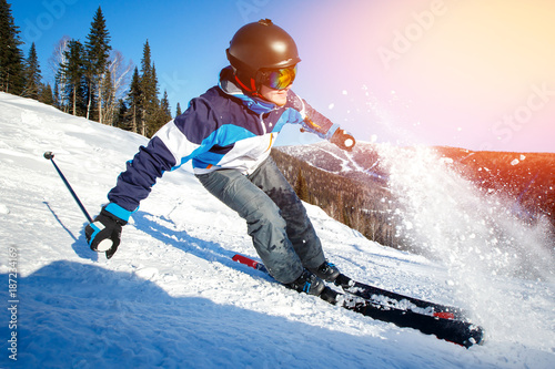 Action camera skier skiing downhill in high mountains during sunny day.