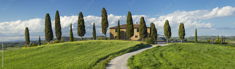 panorama with green field and farm house in Tuscany in Italy