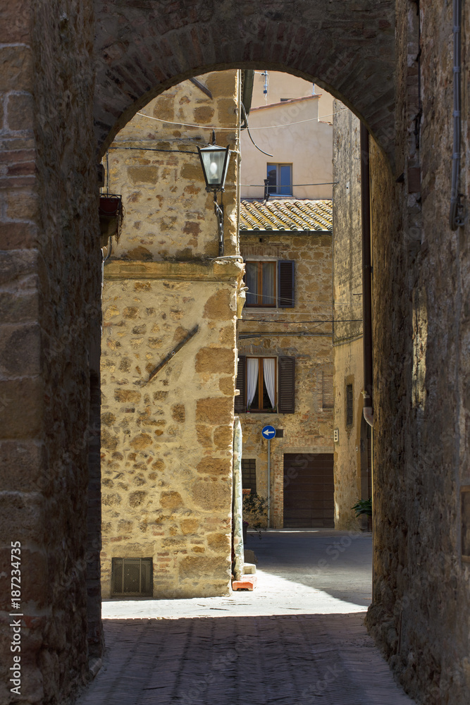 Obraz premium view through arch in old city in Italy