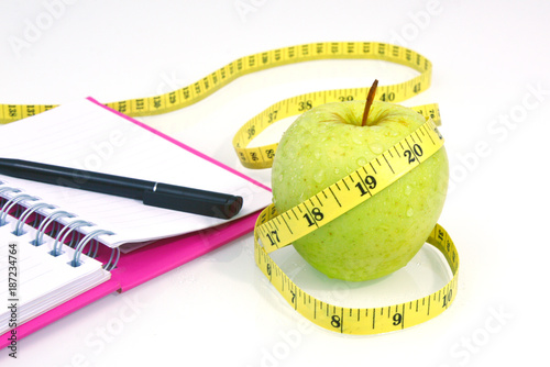 Green apple with measuring tape on white background