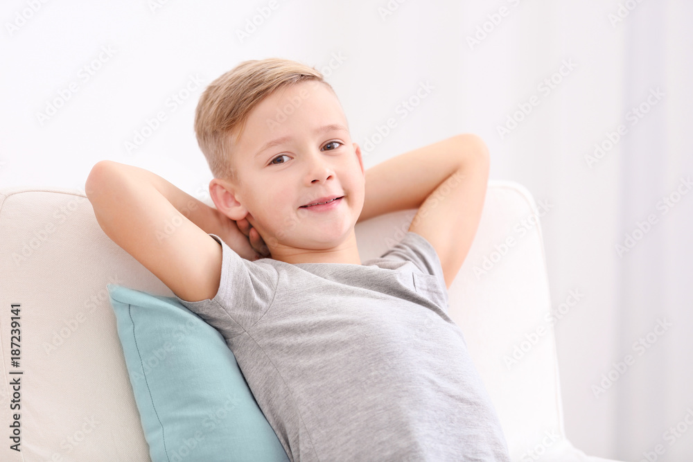 Cute boy resting in armchair with soft pillow at home Cute boy resting in armchair with soft pillow at home