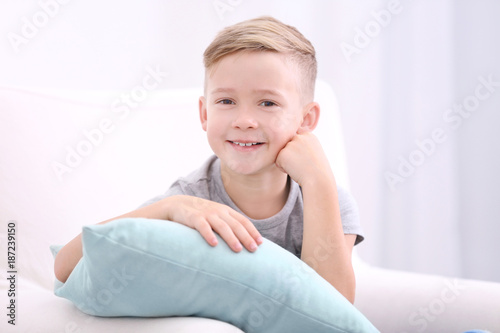 Cute boy with soft pillow a...