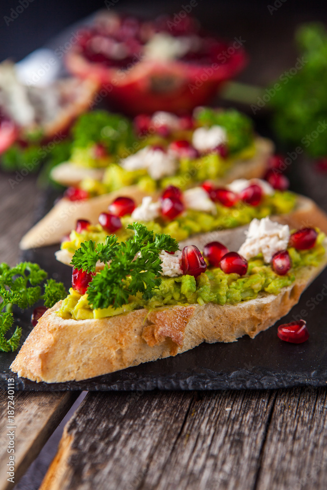 Φωτογραφία Toast with avocado and pomegranate on wooden table