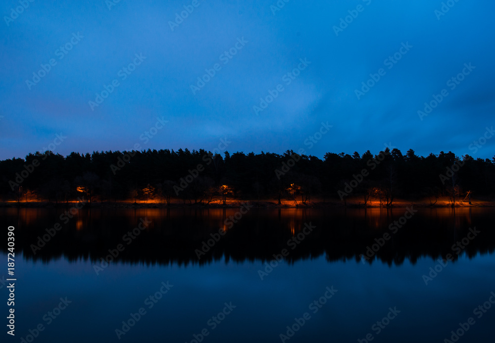 Naklejka premium Park with lights near the river in the night.