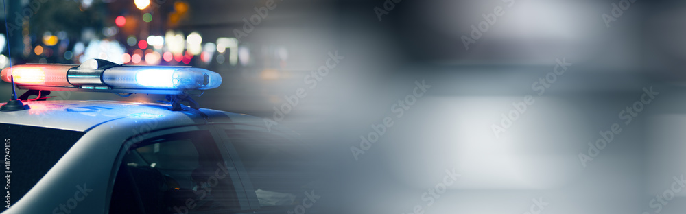 Obraz premium Niebieskie światło migacza na szczycie samochodu policyjnego