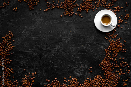 Cup of milky coffee on black table top view copyspace. Coffee background.