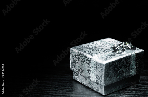 gift box wrapped with white ribbon on dark wooden background. with copy space.