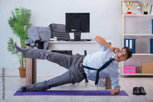 Fototapeta Naklejka Na Ścianę i Meble -  Businessman doing sports in office during break