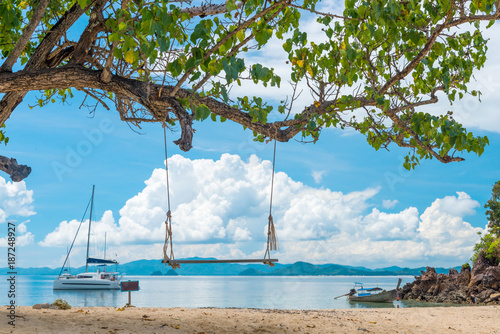 view of a swing against the backdrop of a beautiful sea on a sunny day