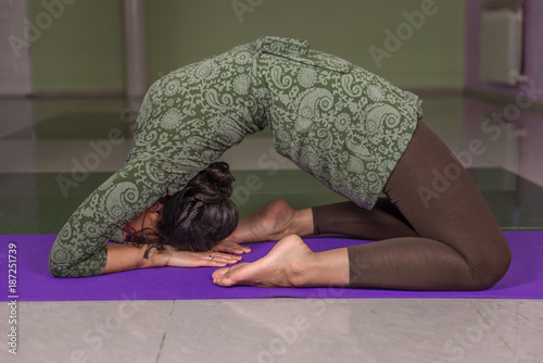 Lady shows yoga positions in fitness class photo