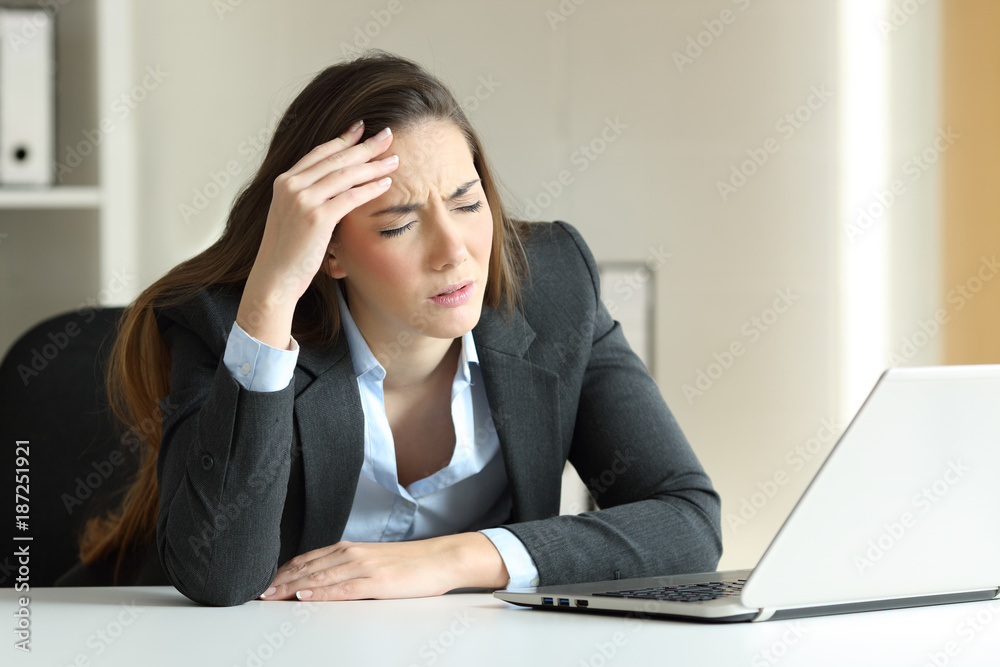 Businesswoman suffering migraine at office Businesswoman suffering migraine at office