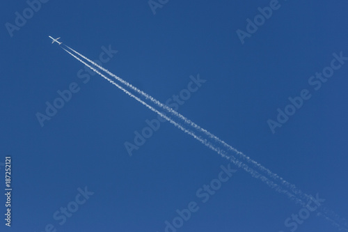 Plane leaving a white contrail, crossing the picture