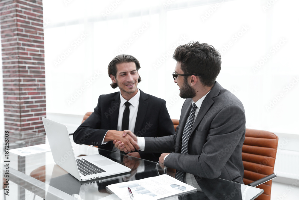 handshake business man sitting behind a Desk. handshake business man sitting behind a Desk.