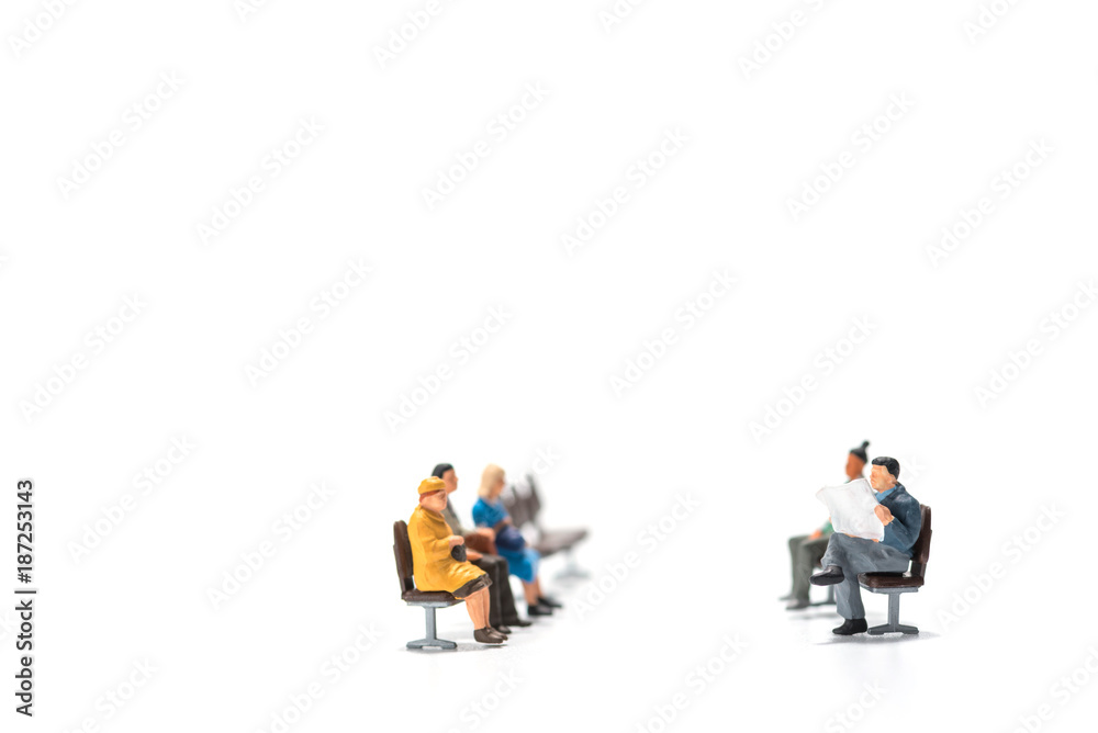 rows of miniature people figure sitting on bench white background