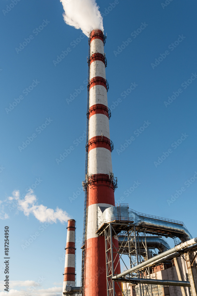 combined heat and power plant, from the pipe goes white smoke against a background of pure blue sky combined heat and power plant, from the pipe goes white smoke against a background of pure blue sky