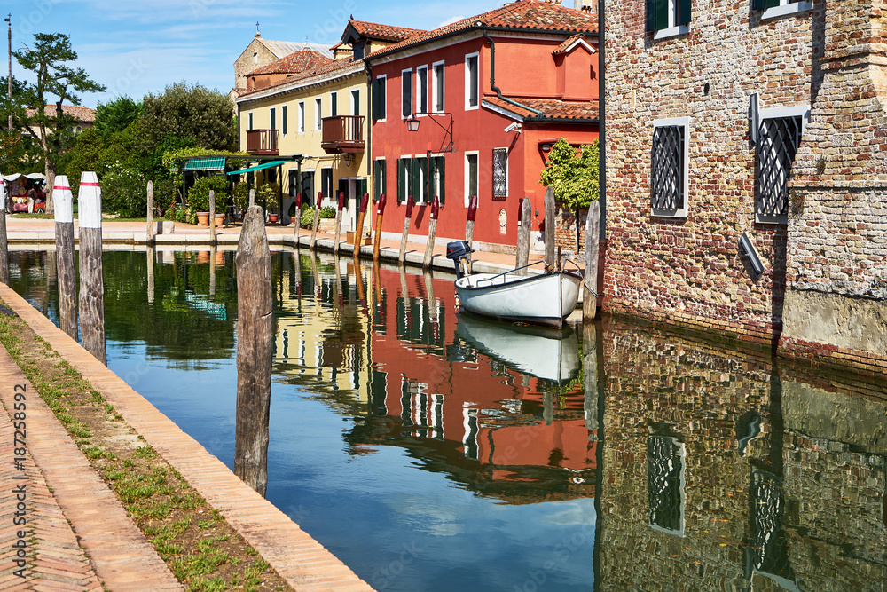 Naklejka premium Torcello, Venice. Colorful houses on Torcello island, canal and boats. Summer, Italy