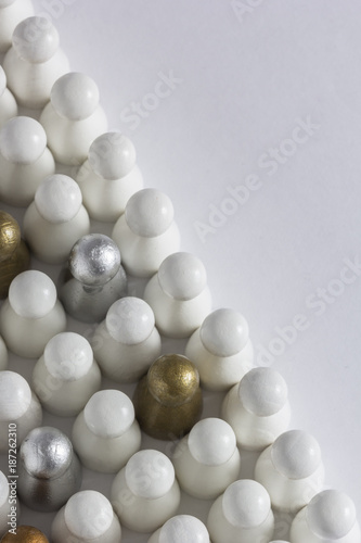 Playful Concepts: Gold, Silver and Bronze game pieces in a crowd of white pieces 