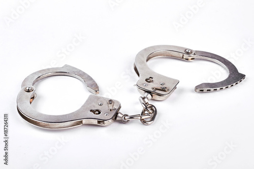 Pair of metal handcuffs over white background. Silver handcuffs isolated on white.