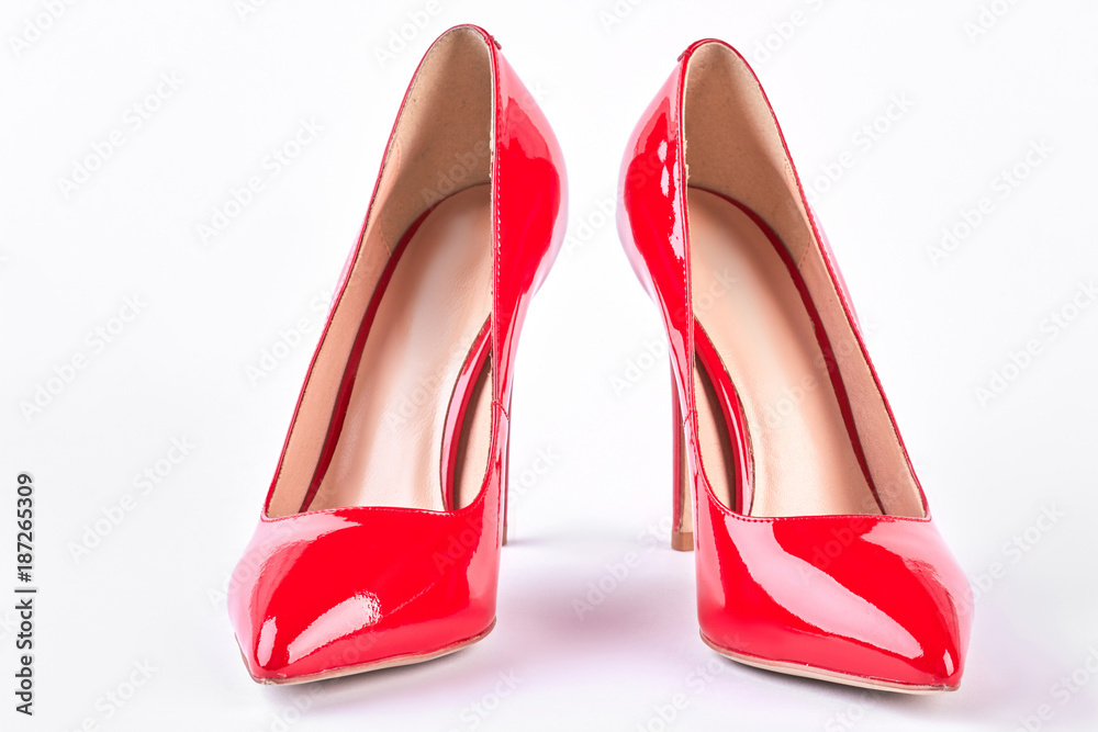 Pair of red heels on white background. Lady fashionable leather shoes on heels, white background. Female fashion style. Pair of red heels on white background. Lady fashionable leather shoes on heels, white background. Female fashion style.
