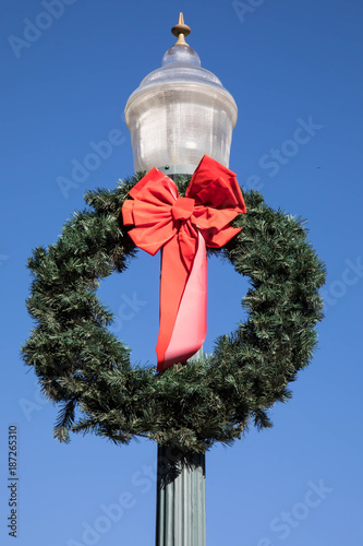 Christmas wreath on a lamp post against blue sky