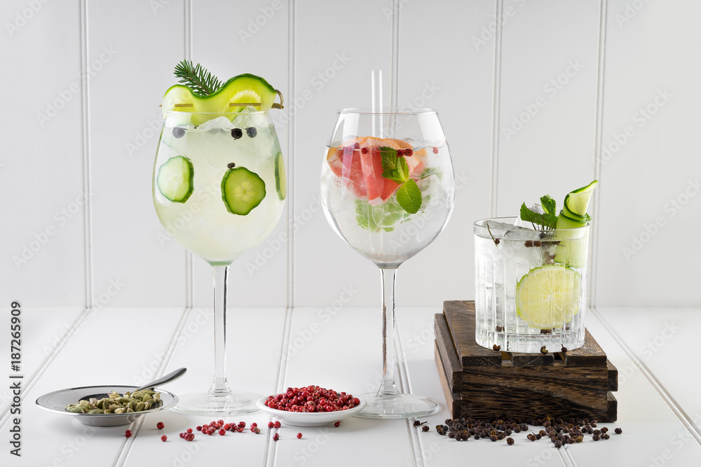 gin and tonic alcohol drink cocktail glass ice fruit garnish plain black white background