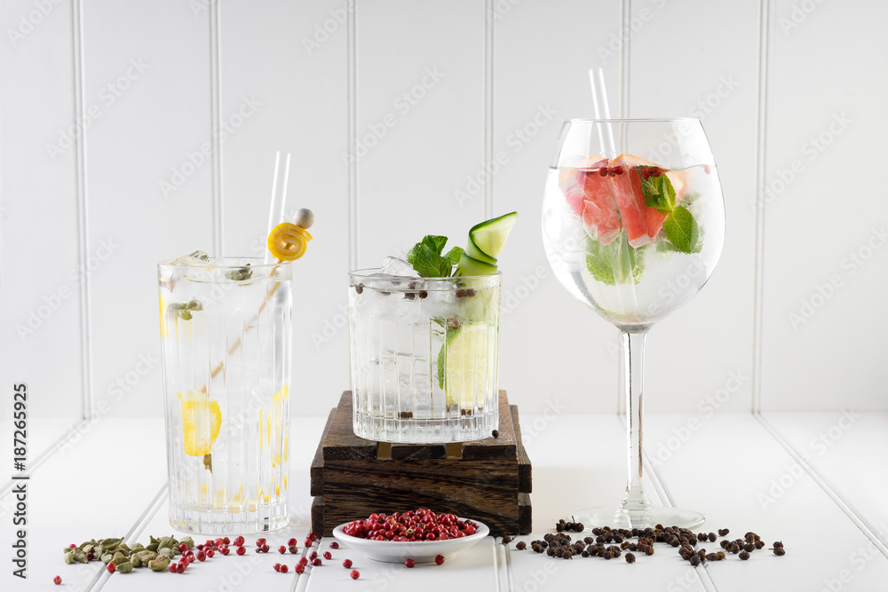gin and tonic alcohol drink cocktail glass ice fruit garnish plain black white background