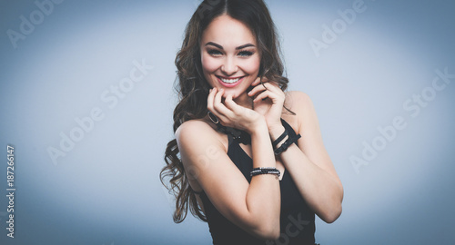 Portrait of a beautiful woman with necklace, isolated on grey background