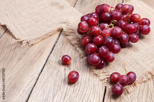 Photography Red grapes on old wooden table background.