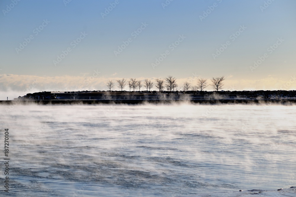 Vapor rises from still flowing water as it turns to Ice on Lake Michigan waters in Chicago's 31st Street Harbor. Winds and bitter cold conspired to create the conditions.