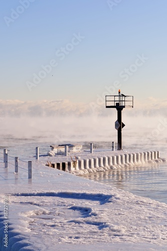 Ice coats a breakwater as vapor rises from the Lake Michigan waters as ice forms in Chicago's 31st Street Harbor. due to the bitter cold.
