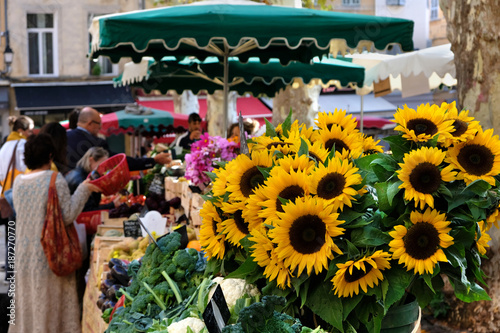 Aix-en-Provence, France - October 18, 2017 : people buying vegetables and flowers in the central provence market square with sunflowers aix en provence photo