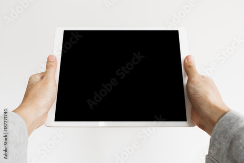 Hands holding modern digital tablet, blank black screen, on white background