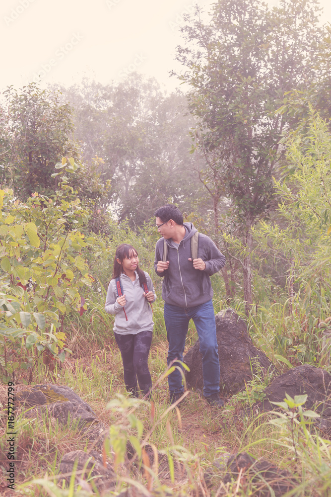 Asia Father and daughter backpack behind go hiking or climbing in Nature Mountain. retro tone.