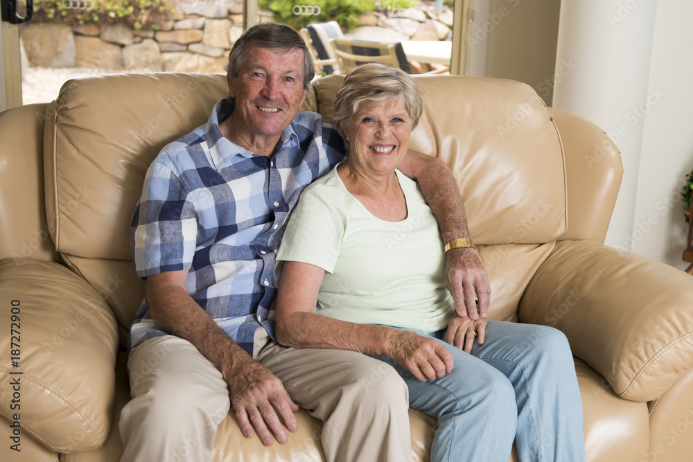 senior beautiful middle age couple around 70 years old smiling happy together at home living room sofa couch looking sweet in lifetime love