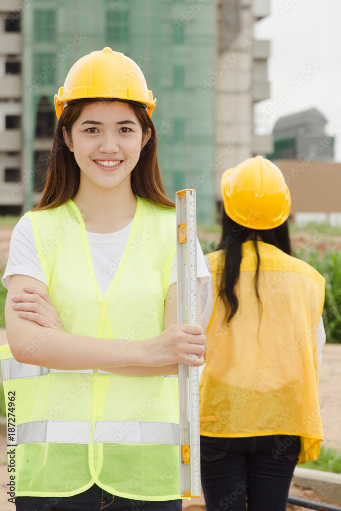 Engineers asian two woman working on plan building construction with paper in site Engineers asian two woman working on plan building construction with paper in site