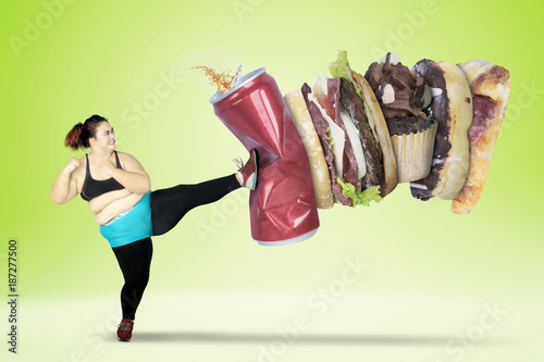 Fat woman kicking fast foods and soft drink