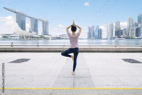 Photography Asian woman meditating in the esplanade bridge