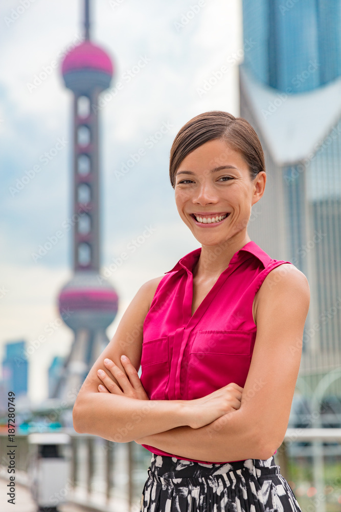 Happy Asian business woman portrait in Shanghai, China Pudong financial district and tower. Proud confident young successful corporate executive or professional Chinese multiracial businesswoman.