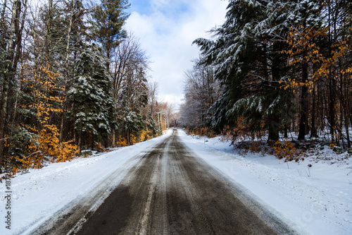 View of empty road passing through forest in winter