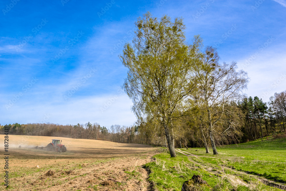 Tractor on field, agriculture and crop in spring, farm land landscape Tractor on field, agriculture and crop in spring, farm land landscape