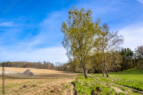 Tractor on field, agriculture and crop in spring, farm land landscape