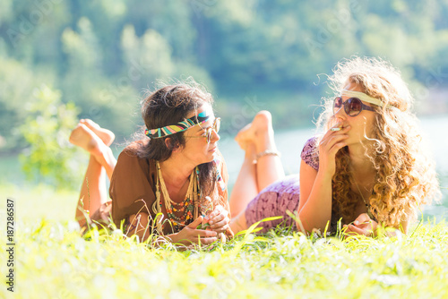 Fototapeta Pretty free hippie girls laying on the grass - Vintage effect photo