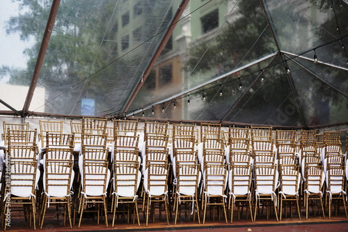 Event Setup Chairs Stacked in Clear Tent in Urban Setting