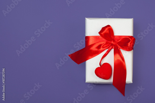 White gift box with red heart on ultra violet background. St. valentine's greeting concept. top view, flat lay