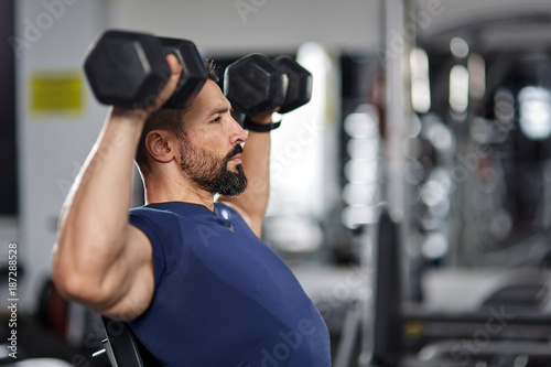 Man doing shoulder workout in the gym